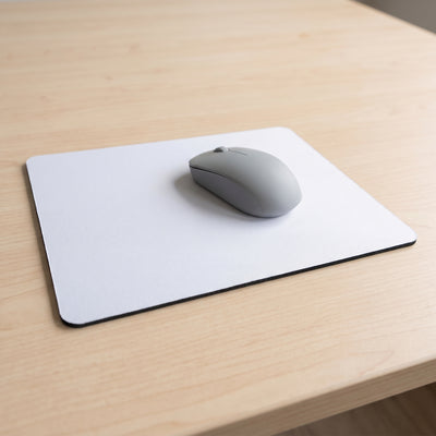 White mouse pad on a timber desk with a computer mouse